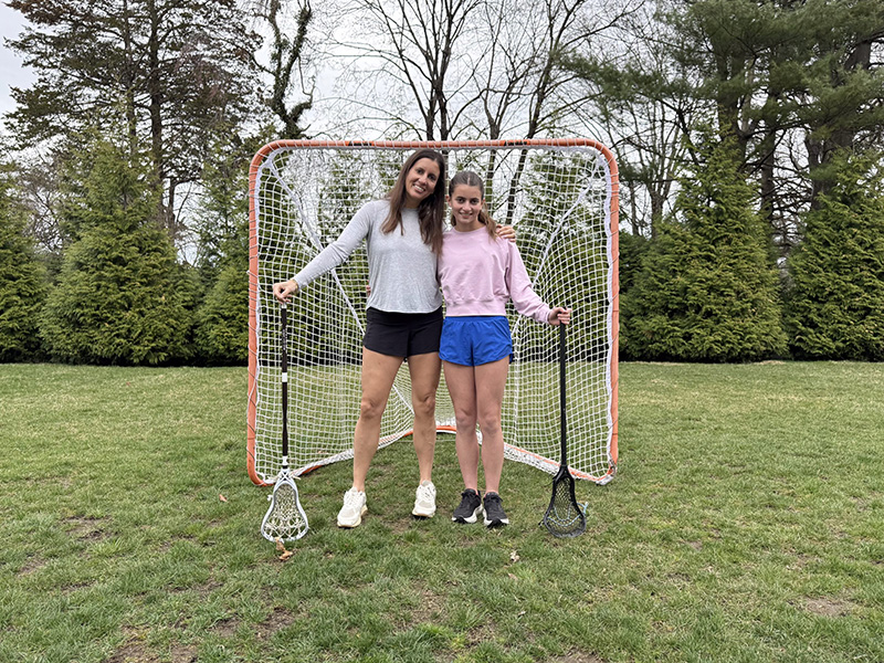 ALT tag (STRICTLY maximum 100 characters): Two young women standing with lacrosse sticks in front of.